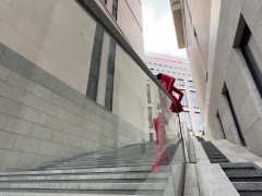 A brunette in lecherous latex and high heels walks around the city