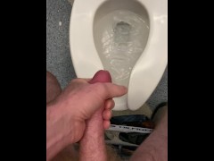 Stroking my dick in the airport bathroom with spit as lube.