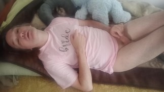 Lying with a teddy bear in a pink T-shirt