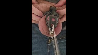 Piss goes all over as caged and pierced slave uses urinal