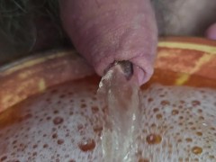 Pissing into a ceramic bowl in the kitchen and spilling the start