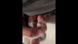 Mann wäscht seinen Penis beim Masturbieren