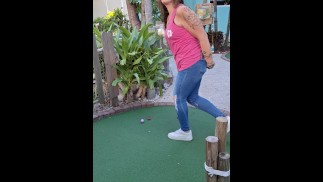 Small petite girl playing golf and not doing good at it