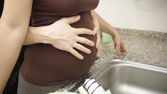 I wash dishes in a brown T-shirt