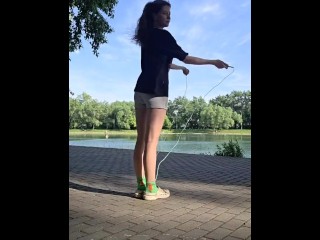 Девушка прыгает со скакалкой на природе