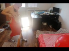 Une femme sexy s'amuse à essayer des vêtements et à les couper. Une brune danse nue dans la maison.